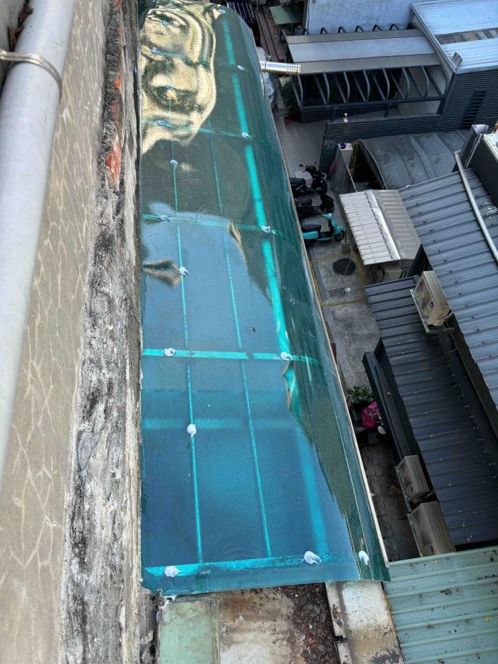 這張「屋頂」的照片是一片透明的玻璃屋頂,屋頂上有金屬支架,並且裝設在牆壁上。