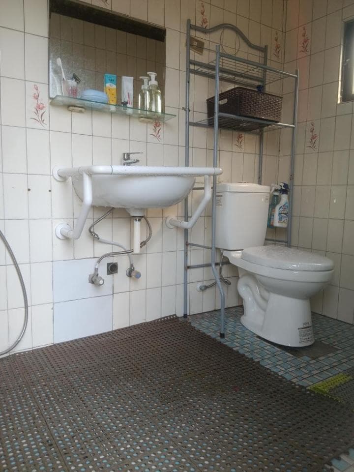 1) 照片顯示一個浴室,裡面有一個馬桶,一個洗手台,以及一個鐵架