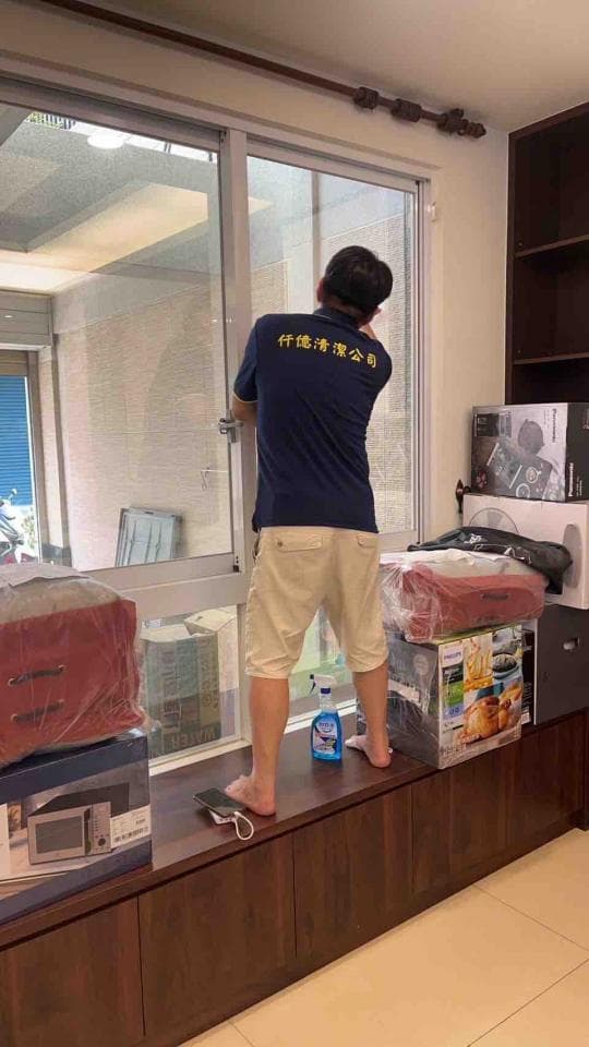 1) 照片顯示一個穿著藍色上衣和米色短褲的男子站在一個木質櫃台上