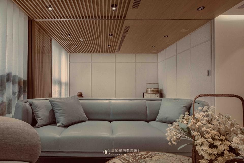 這張「現代風格客廳」的照片是,淺色木質天花板,搭配淺色牆面,擺放灰色的沙發,整體空間簡潔明亮。