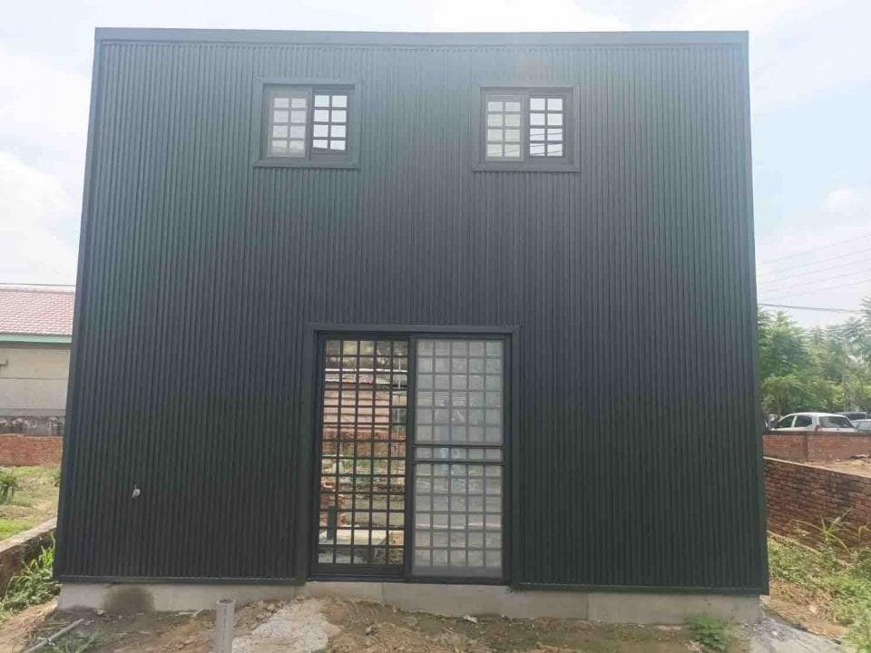 1) 這是一張黑色金屬板牆的建築物照片,牆上裝有兩扇方形窗戶和一扇玻璃門