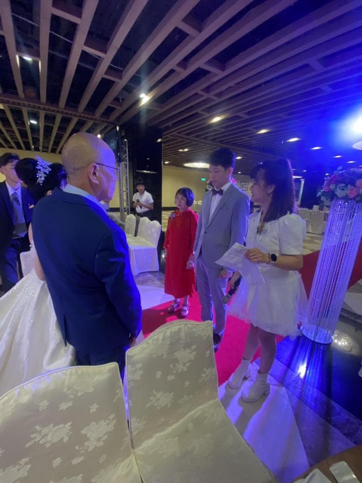 這張婚禮的照片是新郎、新娘、伴郎、伴娘,以及兩位長輩在婚禮現場。