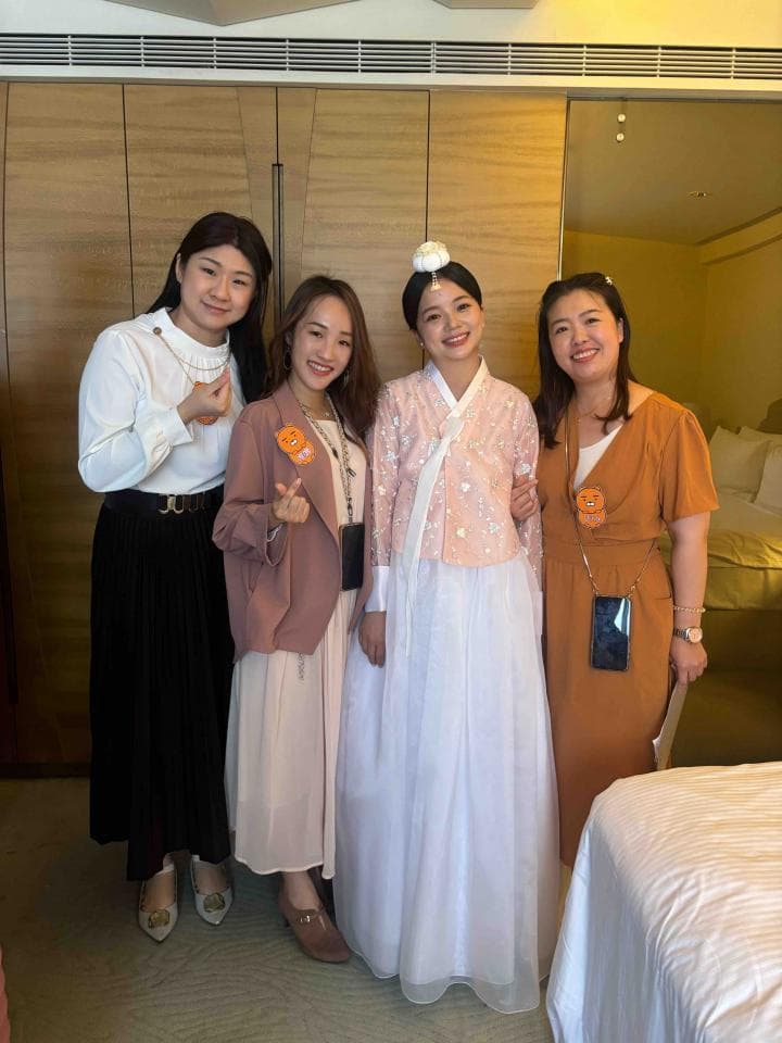 這張「四個女性友人合影」的照片是,她們穿著不同的服裝,站在飯店房間內,看起來很開心,準備一起出去玩。