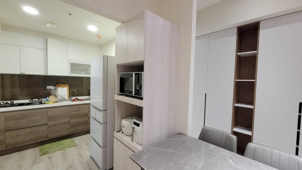 這張照片是一個現代化的廚房,最重要的是一個大型的開放式櫥櫃,其中包括一個微波爐、一個烤麵包機和一些儲物空間。