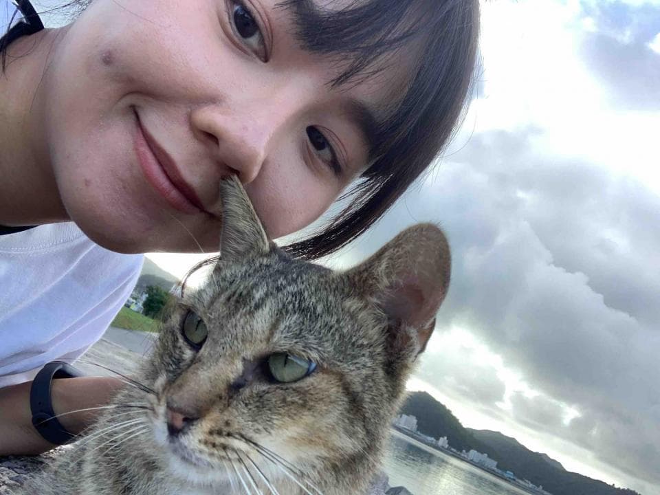 1. 照片中是一名年輕女子,她正在撫摸一隻貓咪