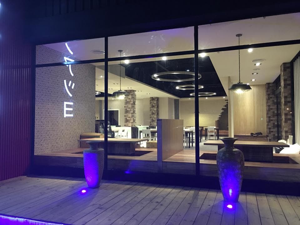 這張照片是一間餐廳的夜景,最重要的是牆上霓虹燈招牌上的"NINE"字樣。