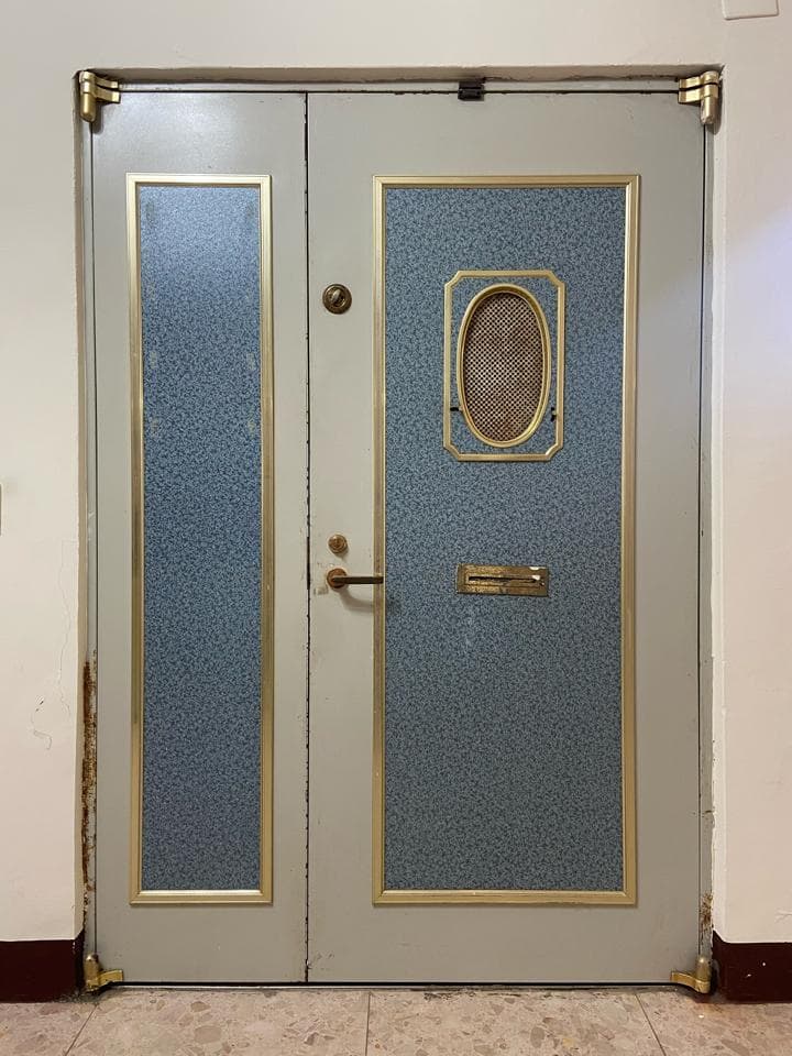 1. 照片顯示一扇雙扇門,上面有金色裝飾和一個郵箱