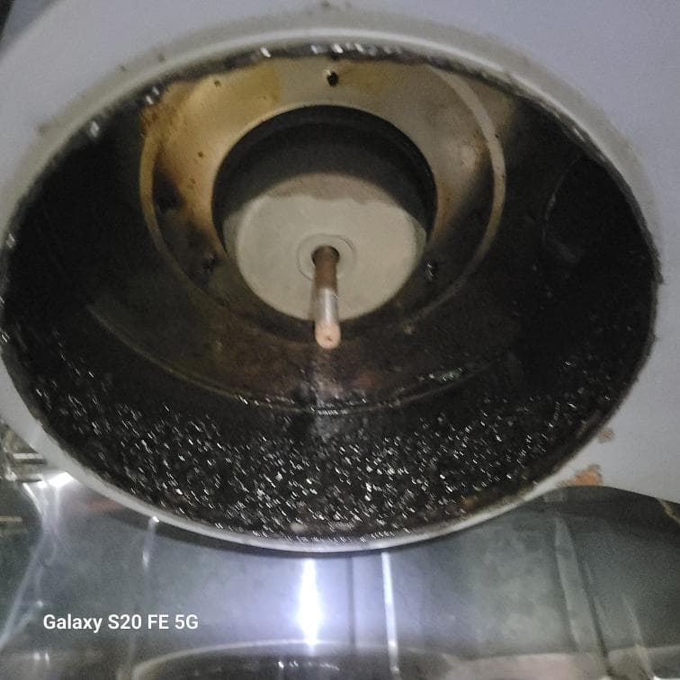 1) 照片顯示一個被油污沾染的白色金屬圓形容器,容器內有一個金屬桿