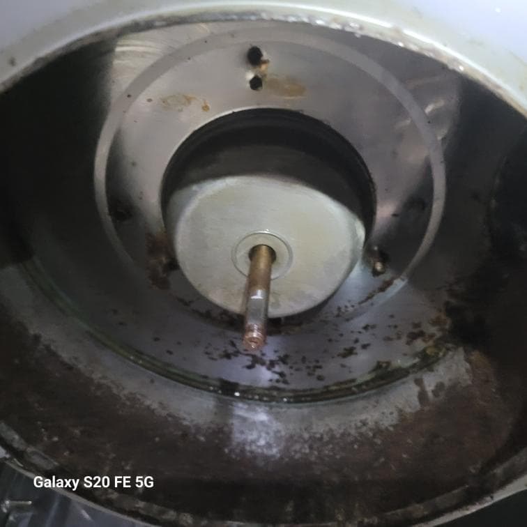 1) 照片顯示一個圓形的金屬物件,內部有鏽蝕,中間有一個圓形的金屬物件,有一個金屬軸穿過它