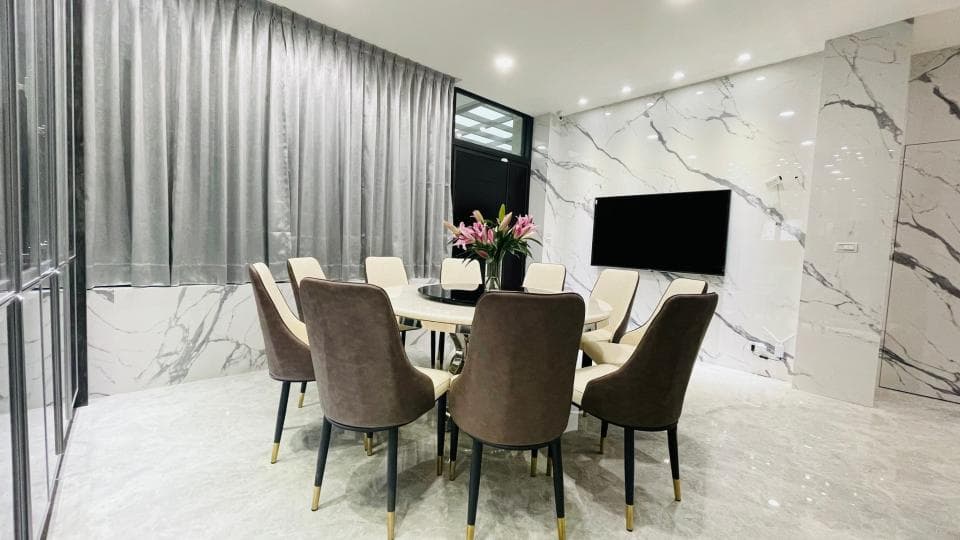 1) 照片顯示一個現代化的客廳,裡面有一張玻璃餐桌和六張棕色皮革椅子