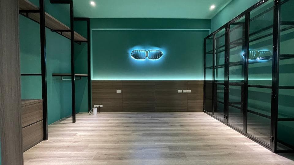 1) 照片顯示一個現代化的臥室,房間的牆壁漆成綠色,木地板是灰色的