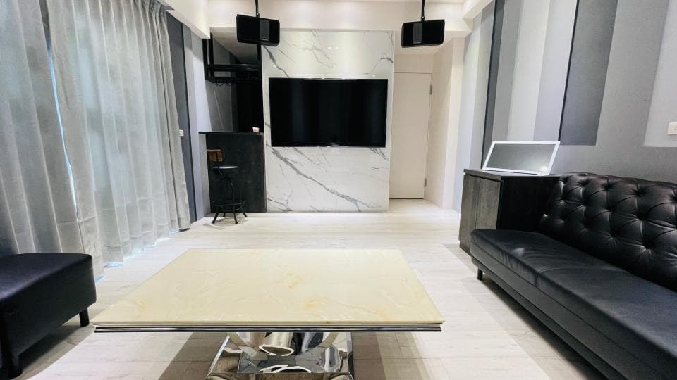 1) 照片顯示一個時尚的客廳,有白色大理石牆面、電視和沙發