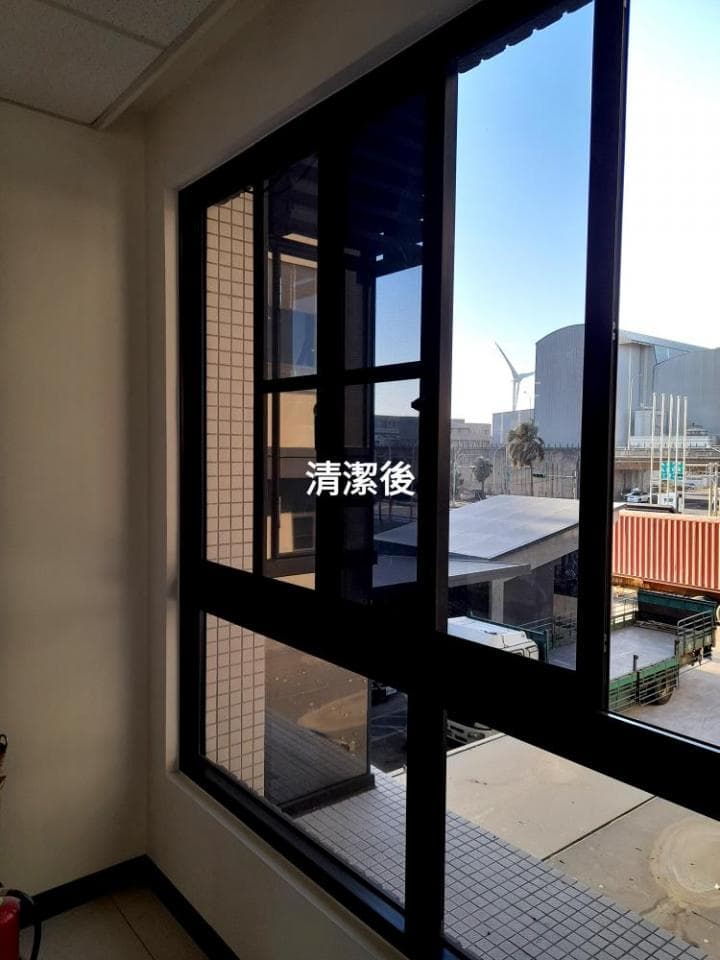 1) 照片顯示一扇大窗戶,窗戶由多個窗格組成,其中一些窗格覆蓋著深色窗簾,透過窗戶可以看到窗戶外建築物和天空