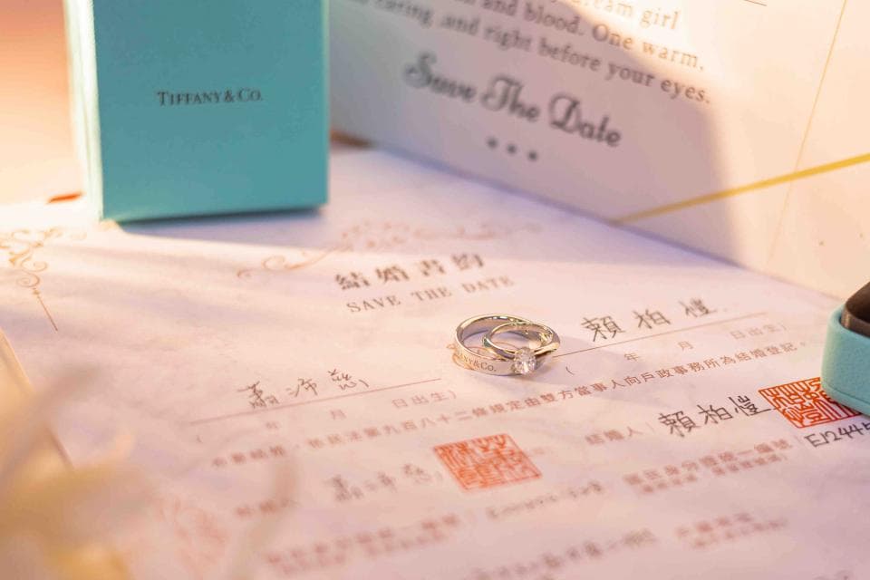 這張照片是一個婚禮的邀請卡,最重要的是卡片中央的婚戒,象徵著幸福與愛情。