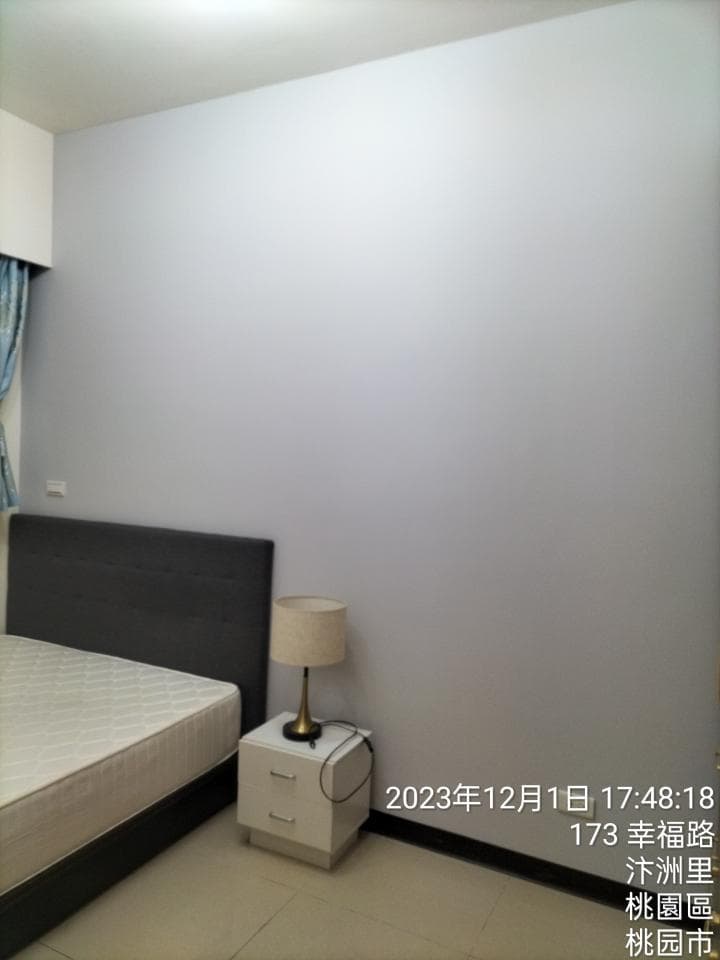 1) 照片顯示一個帶有床頭板的床和一張床頭櫃,床頭櫃上有一個台燈