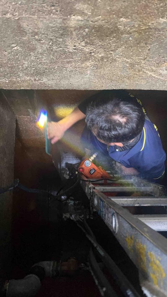 1) 照片中,一名男子站在梯子上,正使用焊槍焊接管道