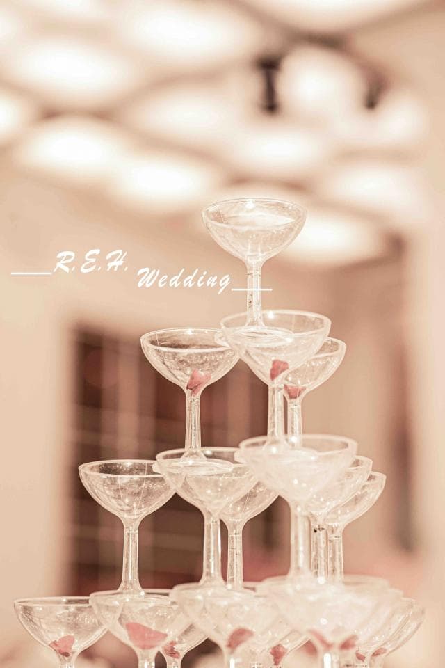 這張照片是一對新人婚禮的香檳塔,由多個香檳杯層層疊疊而成,最上面的是一個單獨的香檳杯,象徵著新人的愛情堅定,永恆不變。