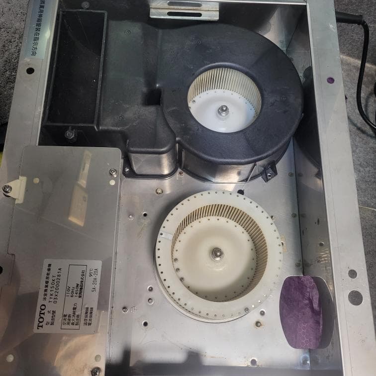 這張照片是一個抽油煙機的内部,最重要的是兩個風扇,一個是大型的黑色風扇,另一個是小型白色風扇,它們負責吸取厨房的油煙。