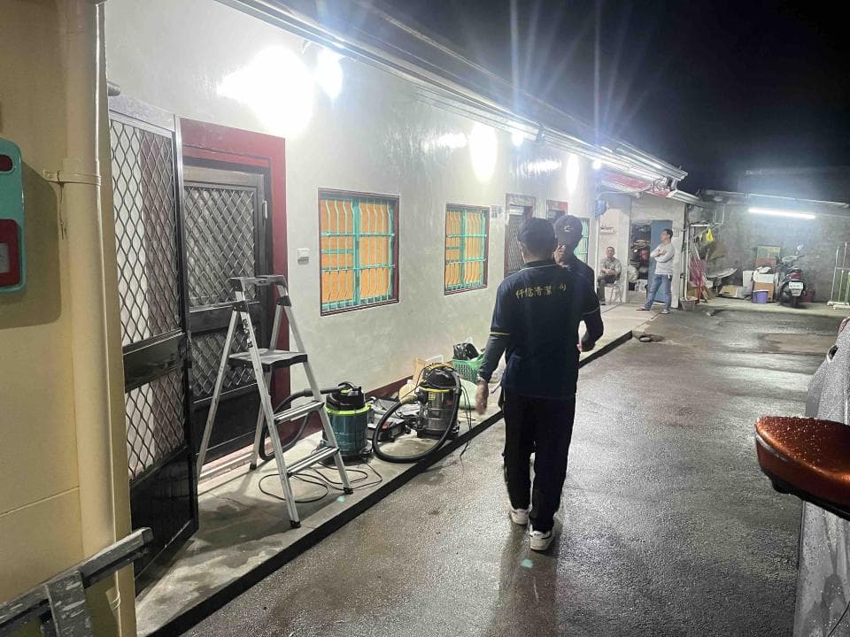 1) 照片顯示一間房屋的外部,門廊左側有扶梯,右側有兩名男子