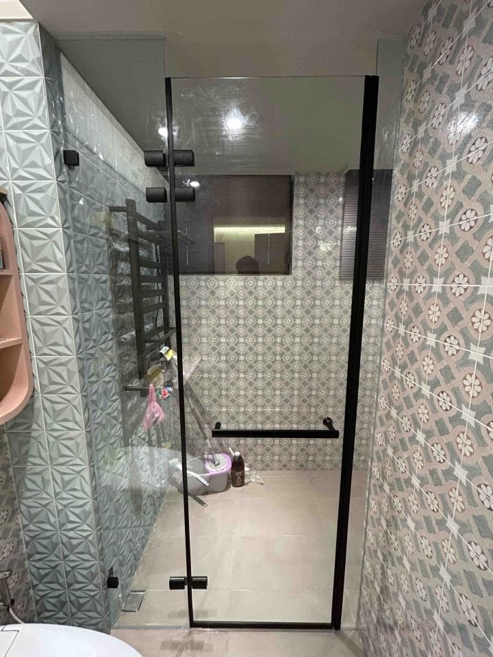 這張照片是一個現代化的浴室,最重要的是黑色框架的淋浴間,它使用透明玻璃,讓人可以清楚地看到裡面。