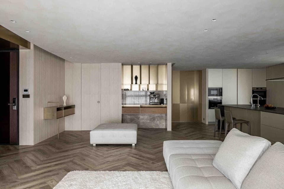 這張「現代風格」的照片是一個寬敞的客廳,地板是木質的,牆壁是淺色的,有一張沙發,一個小茶几和一個壁櫃。