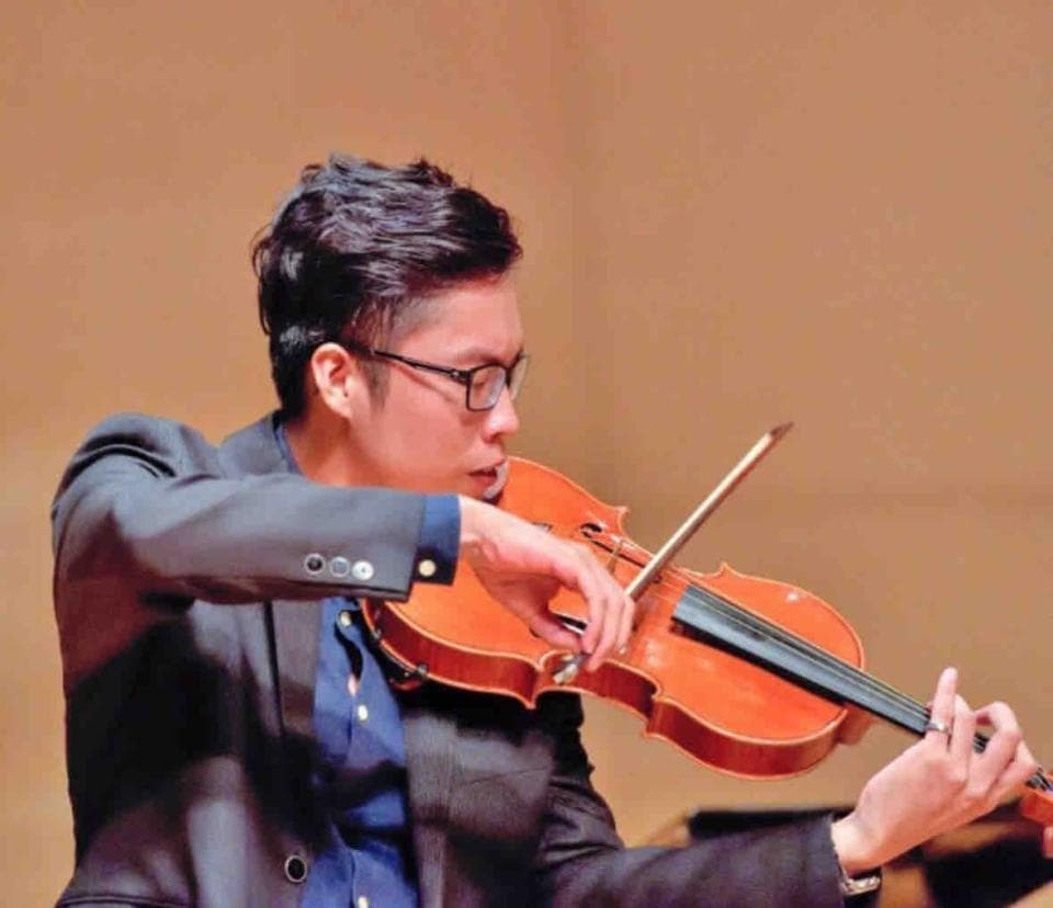 1) 照片顯示一位穿著西裝的男人,手持小提琴演奏