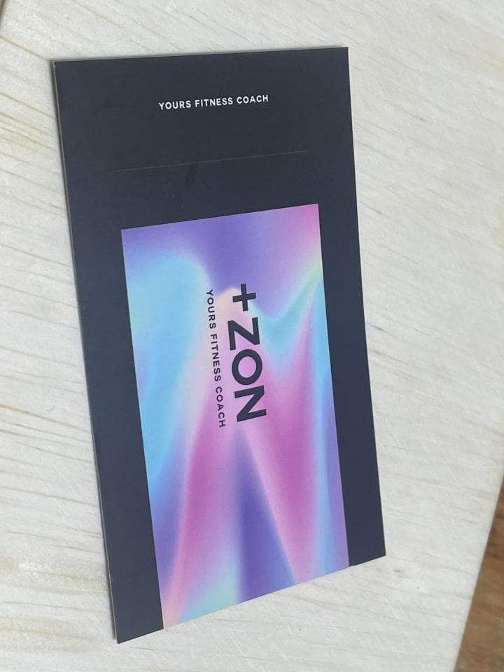 這張「+ZON」的照片是一個健身教練的名片,上面有他們的名字和標誌,背景是一個彩虹色的圖案。