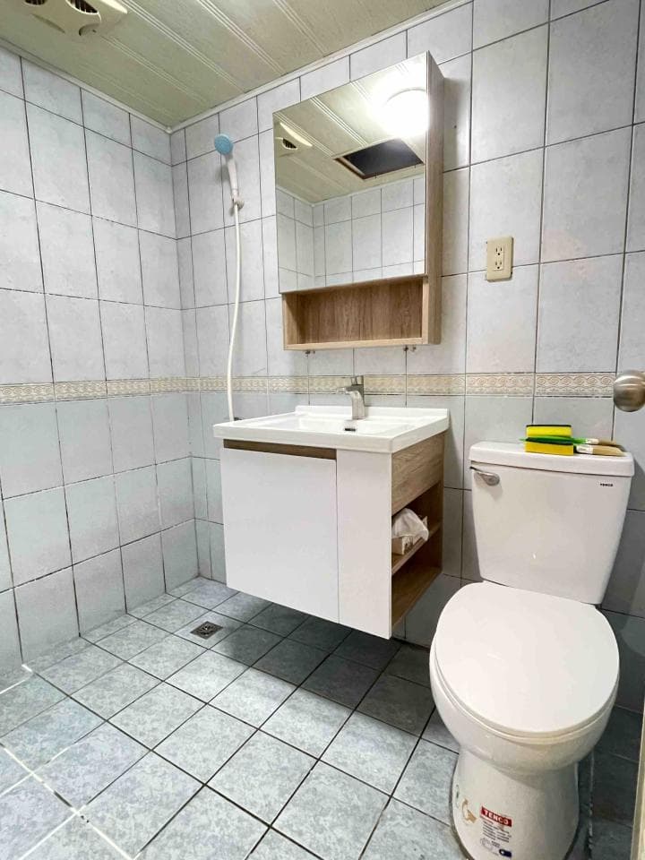 這張照片是一間浴室,最顯眼的部份是浴室的白色馬桶,它乾淨、光亮,而且是浴室裡唯一沒有被任何東西遮擋的家具。