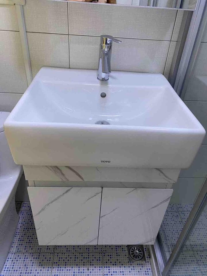 1) 照片顯示一個白色的浴室水槽和櫃子,水槽上有一個銀色的水龍頭