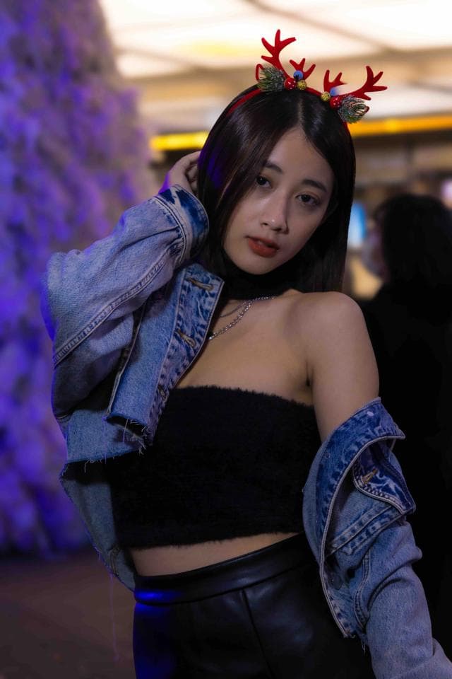 這張「女性」的照片是一個年輕女子,她穿著一件牛仔夾克,露出黑色的短上衣和皮褲,她還戴著一個鹿角頭飾。