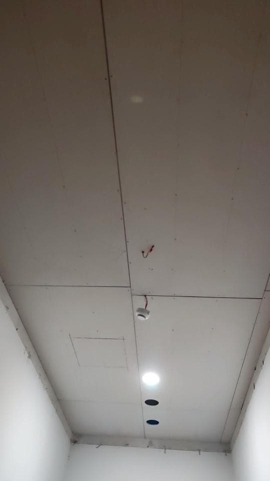 1) 照片显示一个白色的天花板,天花板上安装了两个灯具和一个烟雾探测器