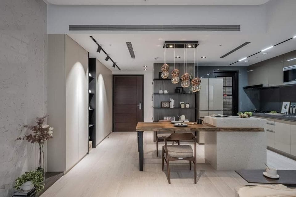 這張「現代化公寓」的照片是一個開放式廚房和餐廳的設計,展示了木質餐桌、現代吊燈和簡約的裝飾風格。