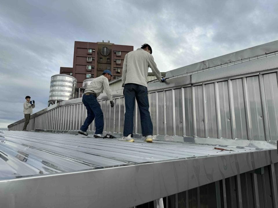 1) 照片顯示三名工人正在屋頂上工作