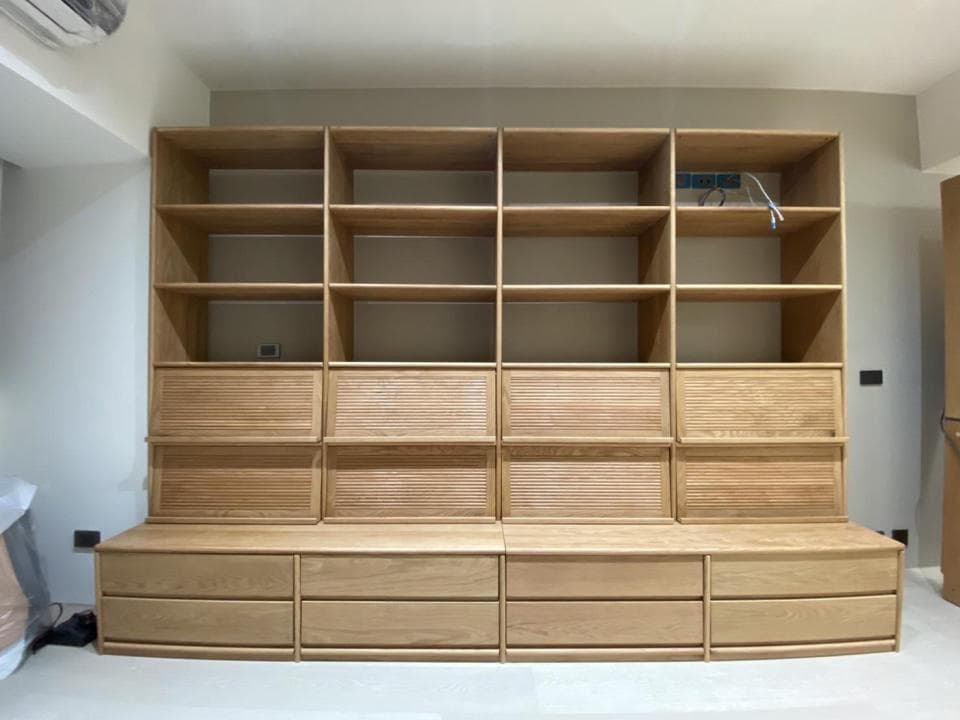 這張照片是一個木質的收納櫃,櫃子上面有許多層架,下方則有抽屜,整體設計簡潔大方,非常適合放置書籍、擺飾等物品。