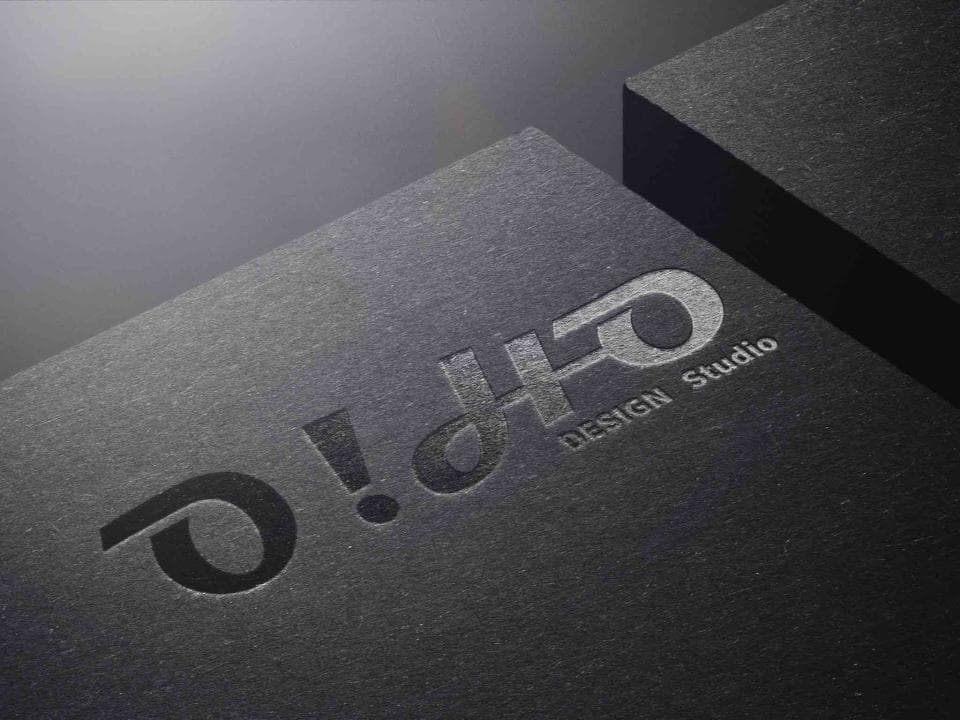這張照片是 O!dHo DESIGN Studio 的商標。商標以銀色字體設計,背景是黑色卡片。商標的字體設計獨特,讓人印象深刻。