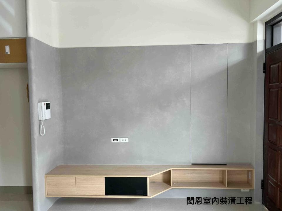 1) 照片顯示一個現代化的客廳空間,牆壁以水泥漆粉刷,並設置了一個簡約的壁架,下方放置一個木質電視櫃
