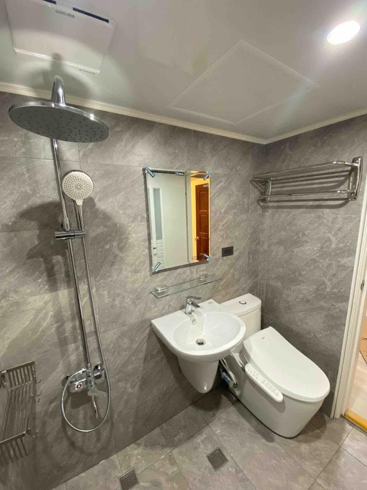 這張照片是一間現代化的浴室,最重要的部分是牆上安裝的馬桶和洗手台,看起來很乾淨,也很時尚。