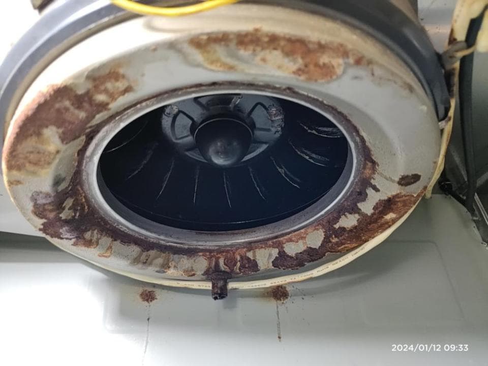 這張照片是一個生鏽的風扇,上面有很多紅色的鏽跡,看起來像是很久沒有清潔了。