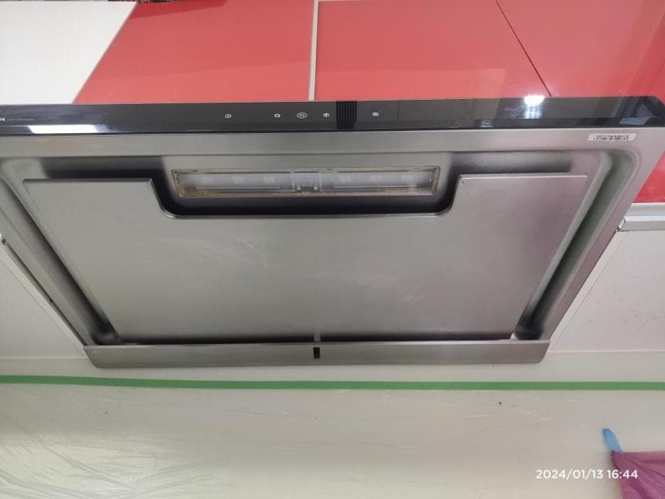 這張照片是一個現代化的抽油煙機,它有一個銀色的外殼,並配有一個燈光照明系統。