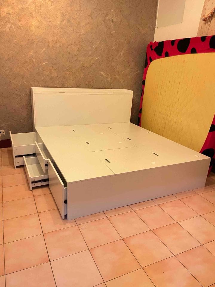 這張照片是一張床,它有許多抽屜,可以儲藏物品。