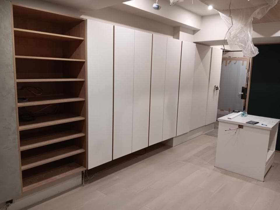 這張照片是木製書架和白色櫃子,書架有六層,擺放在白色櫃子的旁邊。