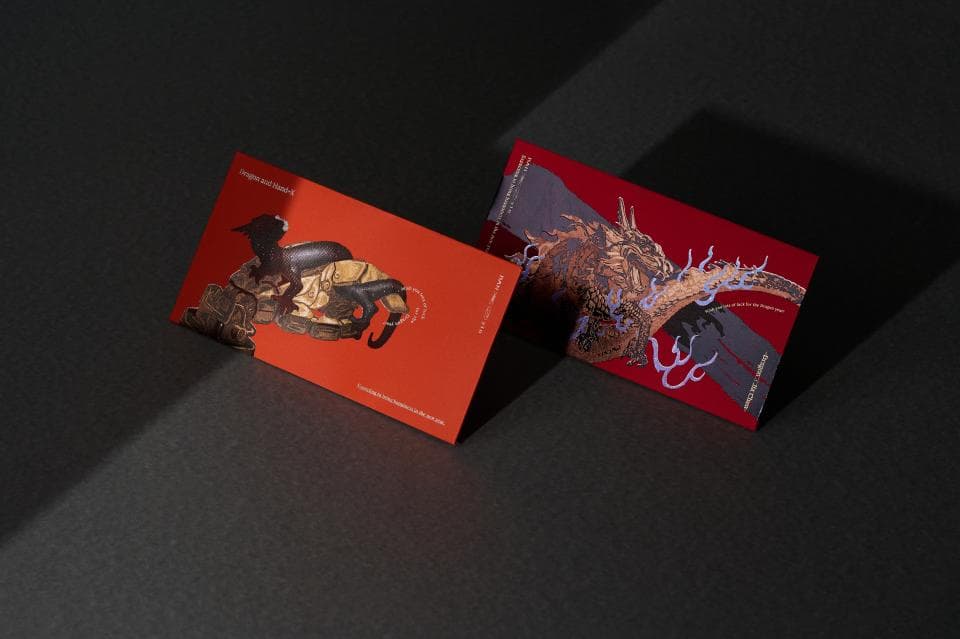 這張「兩張紅色卡片」的照片是,一張卡片上畫著一隻黑色動物,另一張卡片上畫著一隻金色動物。