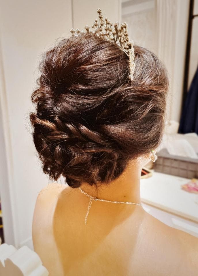 這張照片是一個戴著皇冠的新娘,她的頭髮盤得很漂亮,並戴著一條珍珠項鍊。