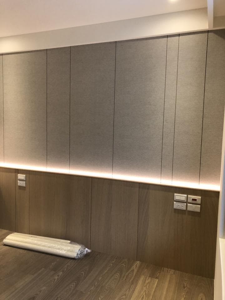 這張照片是一面牆,上面有木板和燈光,還有一排開關。牆壁上有一排隱藏式的燈光,讓牆壁顯得更亮。