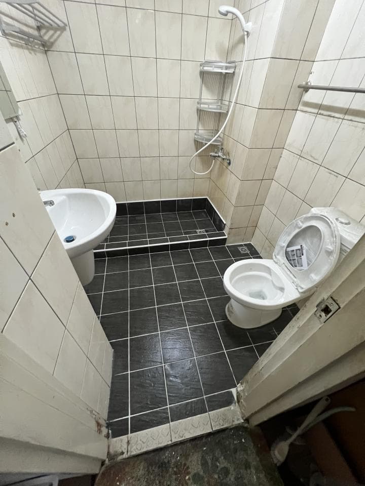 1) 照片顯示一間浴室,浴室有馬桶、洗手台、淋浴間,並鋪設黑色磁磚地板