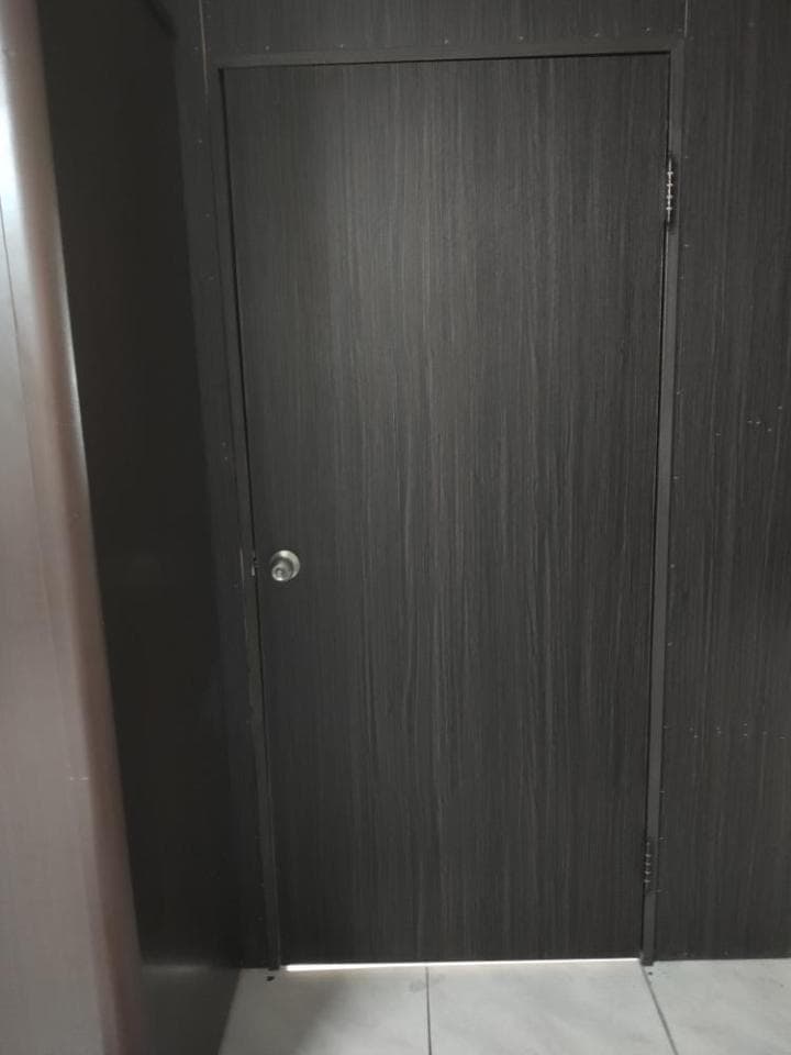 這張照片是一扇深色木紋門,門上有一個銀色的門把。