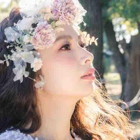 這張照片是一個戴著花環的年輕女子,她的眼神望向遠方,充滿著希望和憧憬。