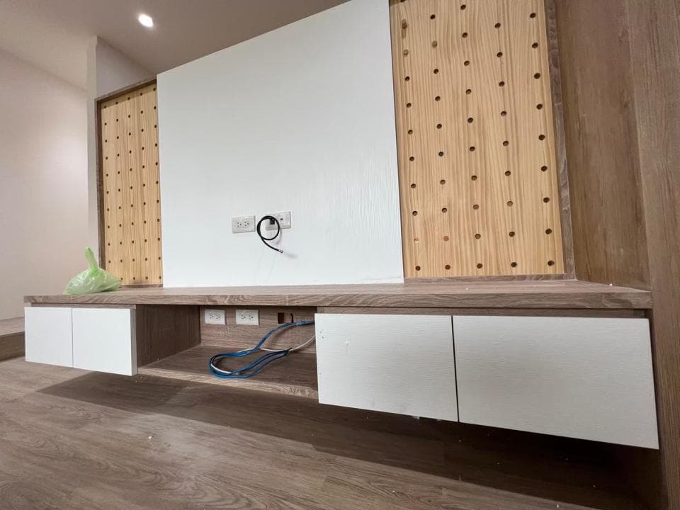 1) 照片顯示一個白色的電視櫃,配有木紋牆板和木紋櫃體,櫃子上有許多小抽屜