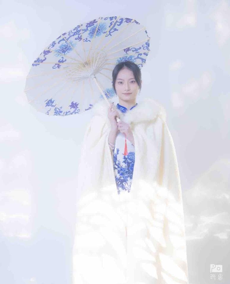 這張「一位穿著白色外套的女子拿著一把有花紋的傘」的照片是。