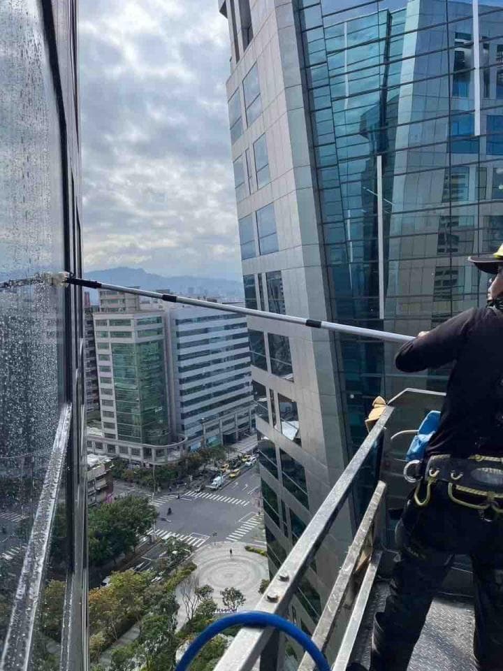 1) 這張照片顯示一個建築工人正在擦拭高樓的窗戶